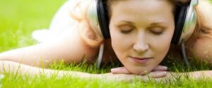 Woman listing to headphones outside