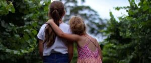 Two young girls walking in the woods