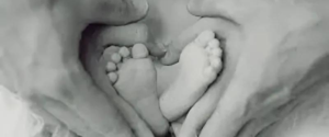 A pair of baby's feet in black and white