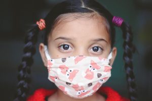 Young girl wearing a mask.