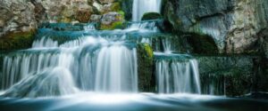 A collection of waterfalls with rocks and a stream