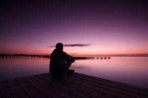 Man meditating on a dock