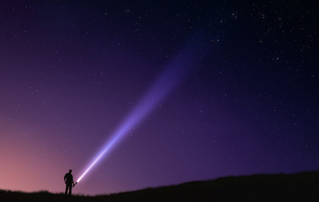 Man with a flashlight outside under the stars in Berkeley