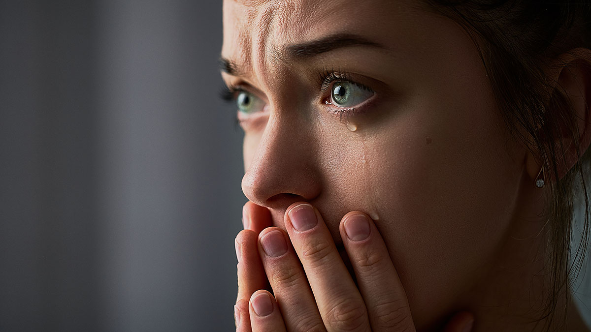 Sad desperate grieving crying woman with folded hands and tears eyes during trouble, life difficulties, depression and emotional problems