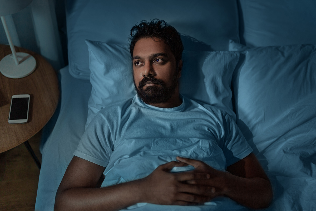 Sleepless man lying in bed at home at night