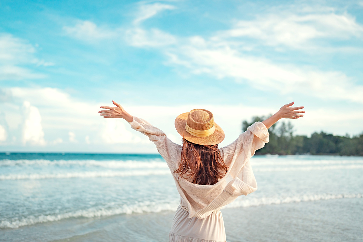 Young woman with hat relaxing on the beach