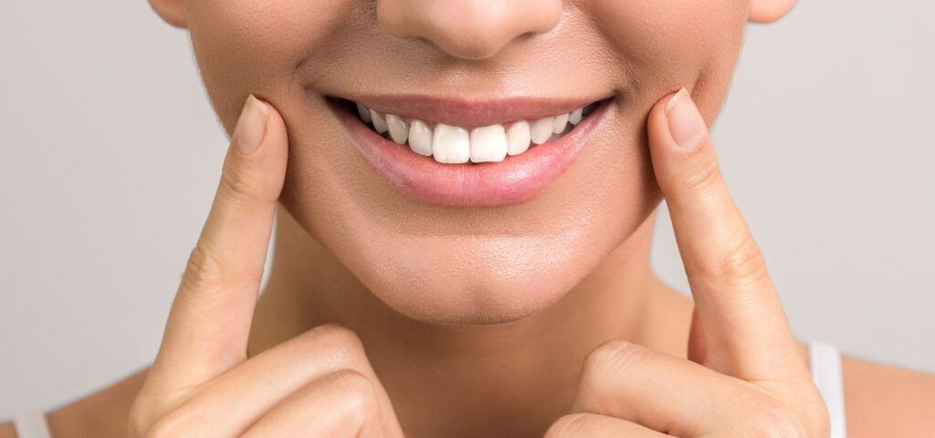 Closeup view of female wide cheerful smile with white teeth.