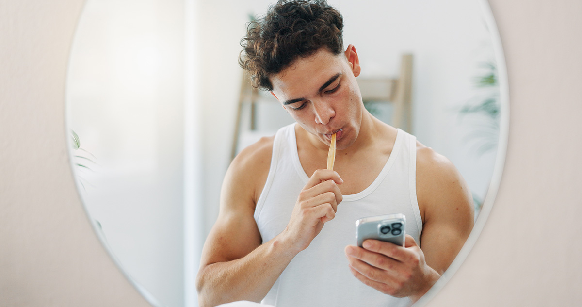 Man brushing his teeth in the mirror