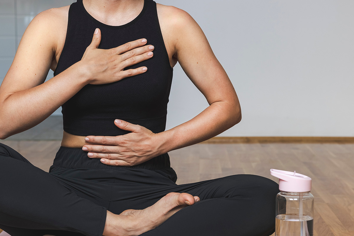 Woman doing breathing exercise sitting in lotus position.